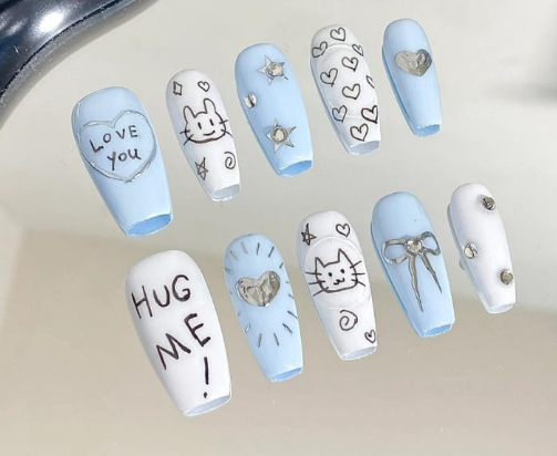 Tổng Hợp Mẫu Nail Màu Xanh Dương Nhạt Đẹp Nhẹ Nhàng Hot Nhất 2025 25 Bộ móng tay giả màu xanh và trắng với họa tiết mèo, nơ, ngôi sao và chữ "LOVE YOU", "HUG ME".