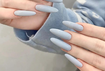 Tổng Hợp Mẫu Nail Màu Xanh Dương Nhạt Đẹp Nhẹ Nhàng Hot Nhất 2025 32 Bàn tay với móng tay dài, sơn màu xanh nhạt, đang chạm vào nhau, áo len xanh nhạt ở nền.