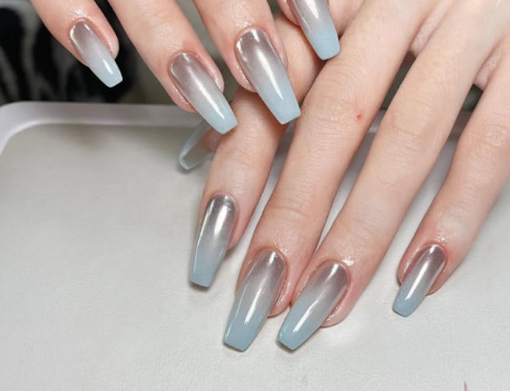 Tổng Hợp Mẫu Nail Màu Xanh Dương Nhạt Đẹp Nhẹ Nhàng Hot Nhất 2025 45 Bàn tay có móng tay dài, được sơn màu ánh kim chuyển từ bạc sang xanh.