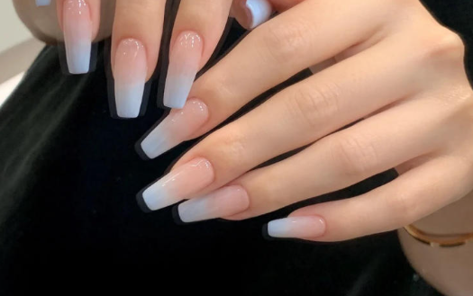 Tổng Hợp Mẫu Nail Màu Xanh Dương Nhạt Đẹp Nhẹ Nhàng Hot Nhất 2025 55 Bàn tay với móng tay dài được sơn kiểu ombre, chuyển từ màu hồng nhạt sang trắng.