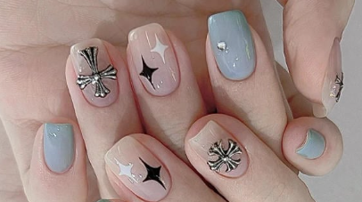 Tổng Hợp Mẫu Nail Màu Xanh Dương Nhạt Đẹp Nhẹ Nhàng Hot Nhất 2025 61 Bàn tay với móng tay được trang trí họa tiết ngôi sao và thánh giá, sơn màu xanh và hồng nhạt.
