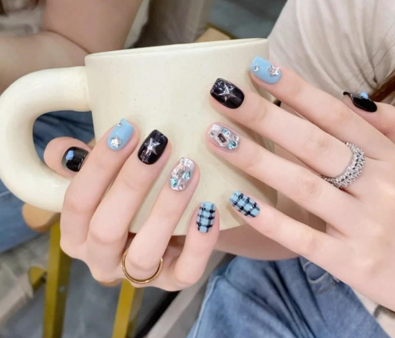 Tổng Hợp Mẫu Nail Màu Xanh Dương Nhạt Đẹp Nhẹ Nhàng Hot Nhất 2025 72 Người cầm cốc sứ trắng, móng tay được trang trí với nhiều màu sắc và hoa văn khác nhau.