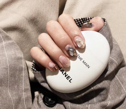 99+ mẫu nail đính đá vừa XINH vừa SANG cho nàng tự tin ra ngoài 19 Tay cầm hộp kem dưỡng da, móng tay được trang trí họa tiết nghệ thuật với nhiều màu sắc khác nhau.