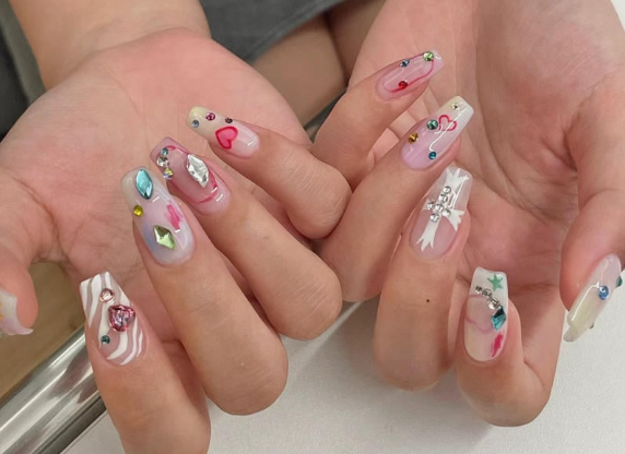 99+ mẫu nail đính đá vừa XINH vừa SANG cho nàng tự tin ra ngoài 27 Bàn tay với móng tay dài, trang trí hoa văn và đá màu sắc đa dạng.