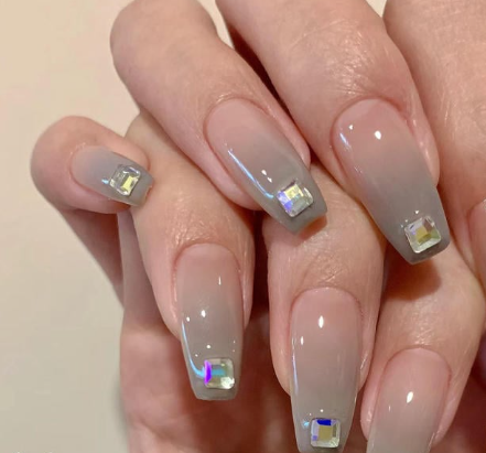 99+ mẫu nail đính đá vừa XINH vừa SANG cho nàng tự tin ra ngoài 33 Bàn tay với móng tay dài, sơn màu xám và đính đá trang trí hình vuông ở đầu móng.