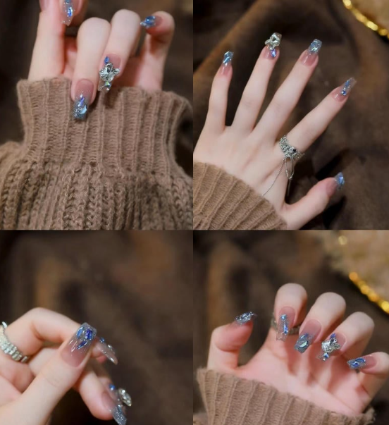 99+ mẫu nail đính đá vừa XINH vừa SANG cho nàng tự tin ra ngoài 40 Bàn tay với móng tay được trang trí bằng họa tiết xanh lấp lánh, đeo nhẫn, trên nền áo len nâu.