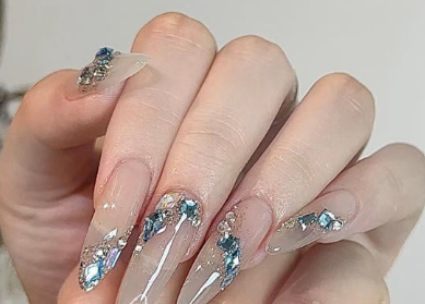 99+ mẫu nail đính đá vừa XINH vừa SANG cho nàng tự tin ra ngoài 43 Bàn tay với móng dài được trang trí bằng đá màu xanh, tạo kiểu cầu kỳ và sáng bóng.