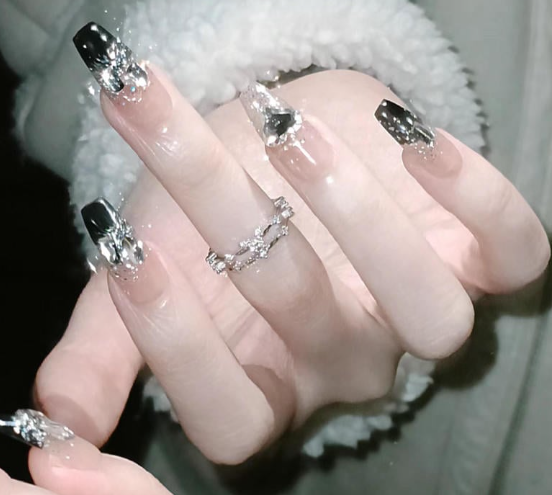 99+ mẫu nail đính đá vừa XINH vừa SANG cho nàng tự tin ra ngoài 47 Bàn tay với móng tay đen và bạc lấp lánh, đeo nhẫn bạc, tạo kiểu thời trang.