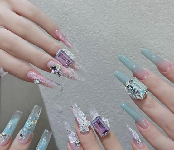 99+ mẫu nail đính đá vừa XINH vừa SANG cho nàng tự tin ra ngoài 57 Bàn tay với móng tay nghệ thuật dài, màu sắc pastel, trang trí đá quý và hoa văn 3D, nổi bật trên nền trung tính.