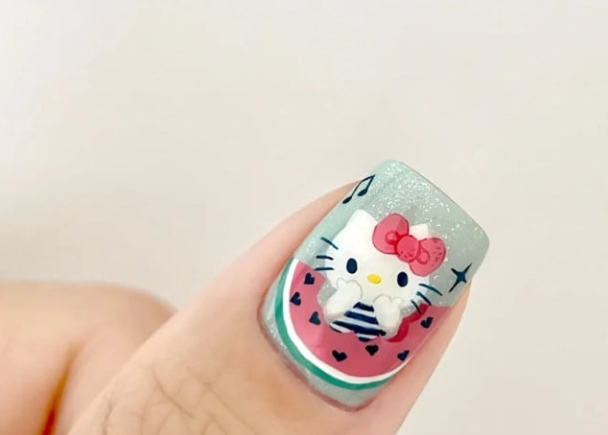 Móng tay được trang trí hình mèo hoạt hình dễ thương với dưa hấu trên nền màu xanh nhạt lấp lánh.