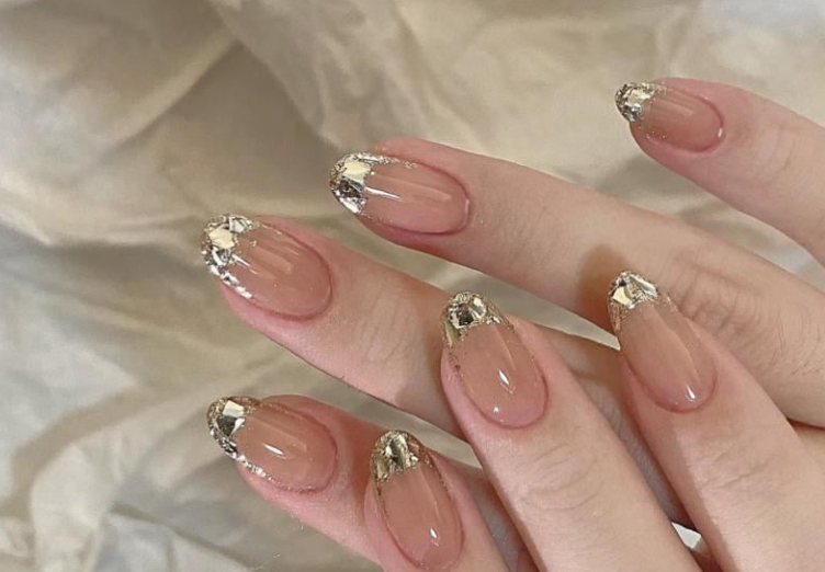 100+ Mẫu Nail Nhũ Đẹp Lấp Lánh Giúp Phái Nữ Tỏa Sáng Thời Thượng 5 Bàn tay với móng tay màu nude, trang trí bằng nhũ bạc ở đầu móng, trên nền vải màu sáng.