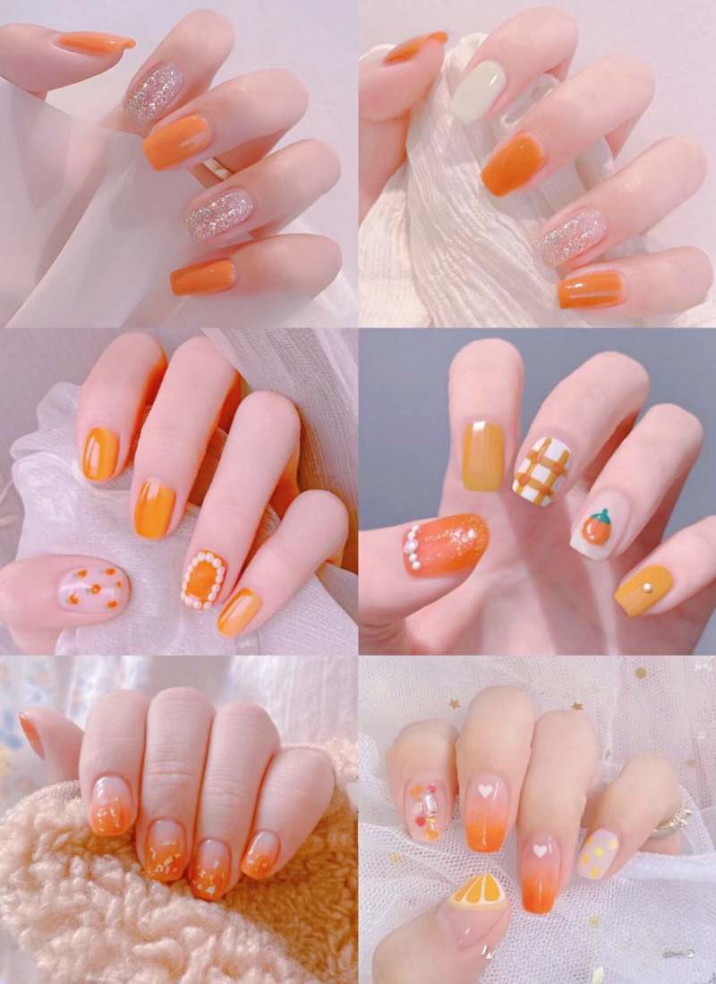 Bộ sưu tập móng tay với các kiểu trang trí đa dạng, chủ yếu là màu cam, có đính hạt và họa tiết khác nhau.