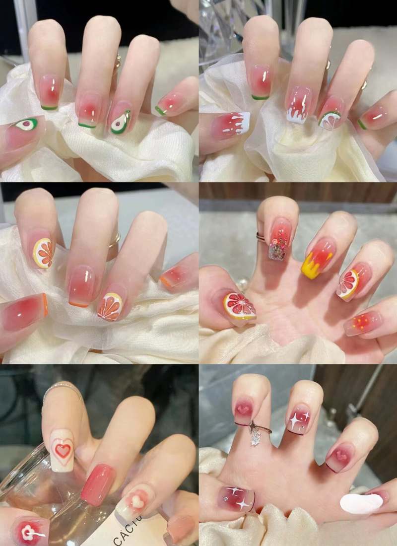 Bộ móng tay với nhiều kiểu trang trí khác nhau, từ họa tiết hoa quả đến hình vẽ và đính đá.