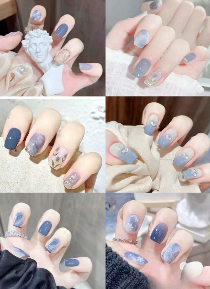 Bộ móng tay với nhiều kiểu trang trí khác nhau, chủ yếu là màu xanh, họa tiết hoa và hình trái tim.