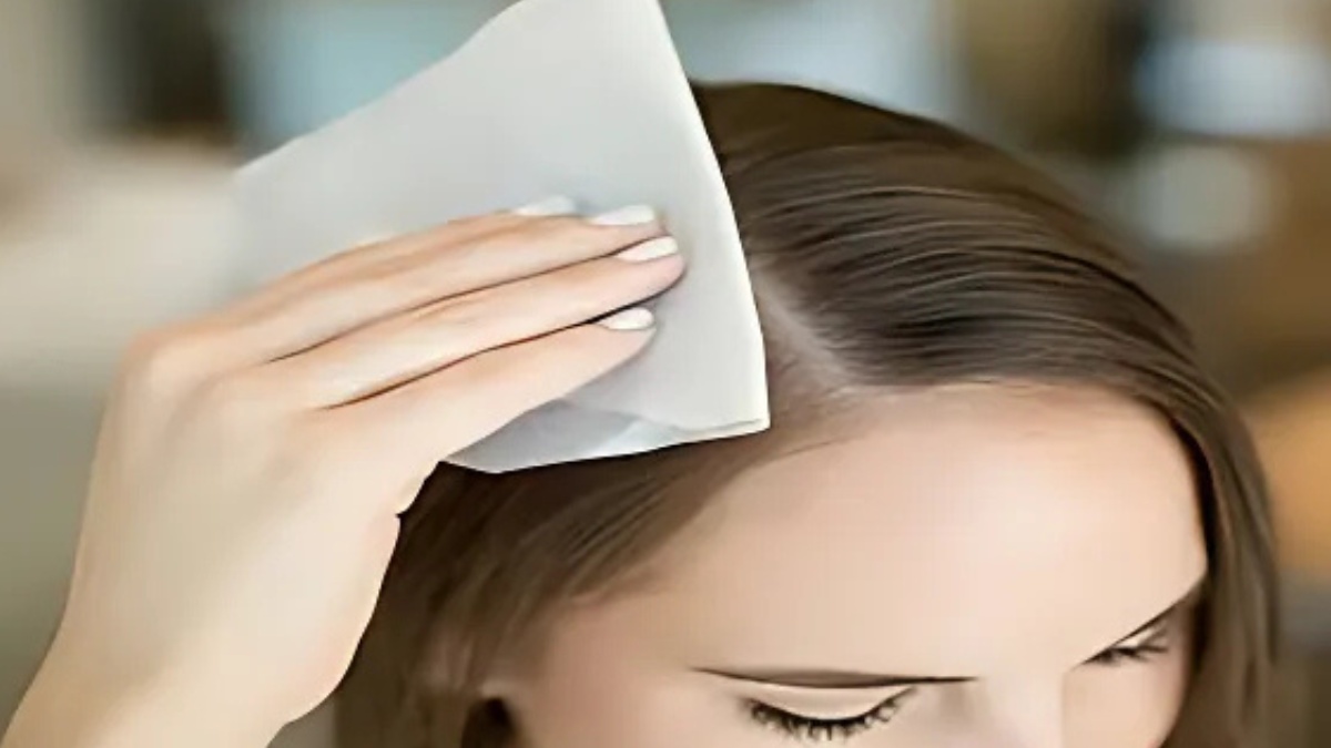 cach-lam-toc-het-bet-khong-can-goi-11 Người đang dùng khăn giấy thấm lên tóc để giảm dầu trên da đầu.