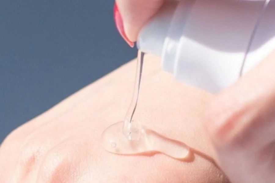 image15-2 Một tay đang bóp tuýp để lấy gel trong suốt ra, thoa lên mu bàn tay.