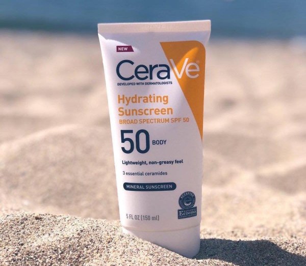 image3-59 Chai kem chống nắng SPF 50 đặt trên cát bãi biển, nền là biển xanh.