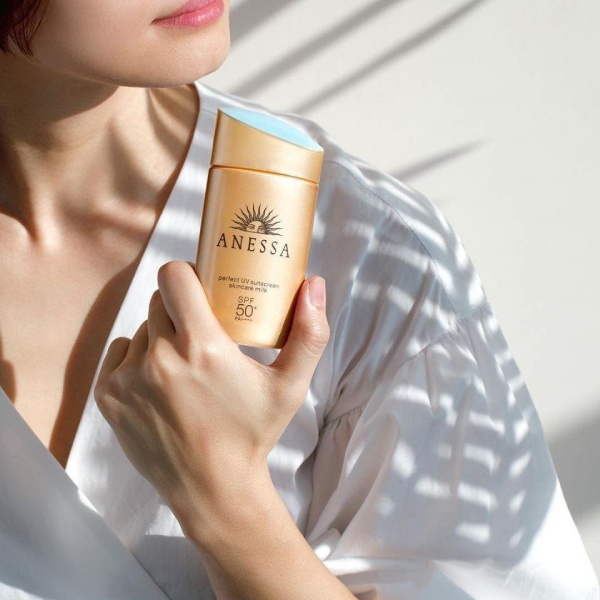 image7-40 Người mặc áo trắng cầm chai kem chống nắng Anessa SPF 50+ dưới ánh sáng mặt trời.