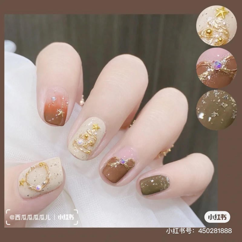 Bàn tay với móng được trang trí họa tiết và màu sắc đa dạng, bao gồm nâu, be, hồng và xanh đậm.