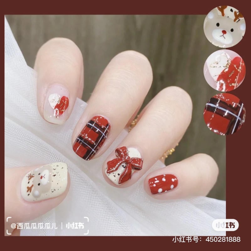 Bàn tay với móng tay trang trí họa tiết tuần lộc, nơ đỏ và họa tiết kẻ caro, phối màu đỏ và trắng.