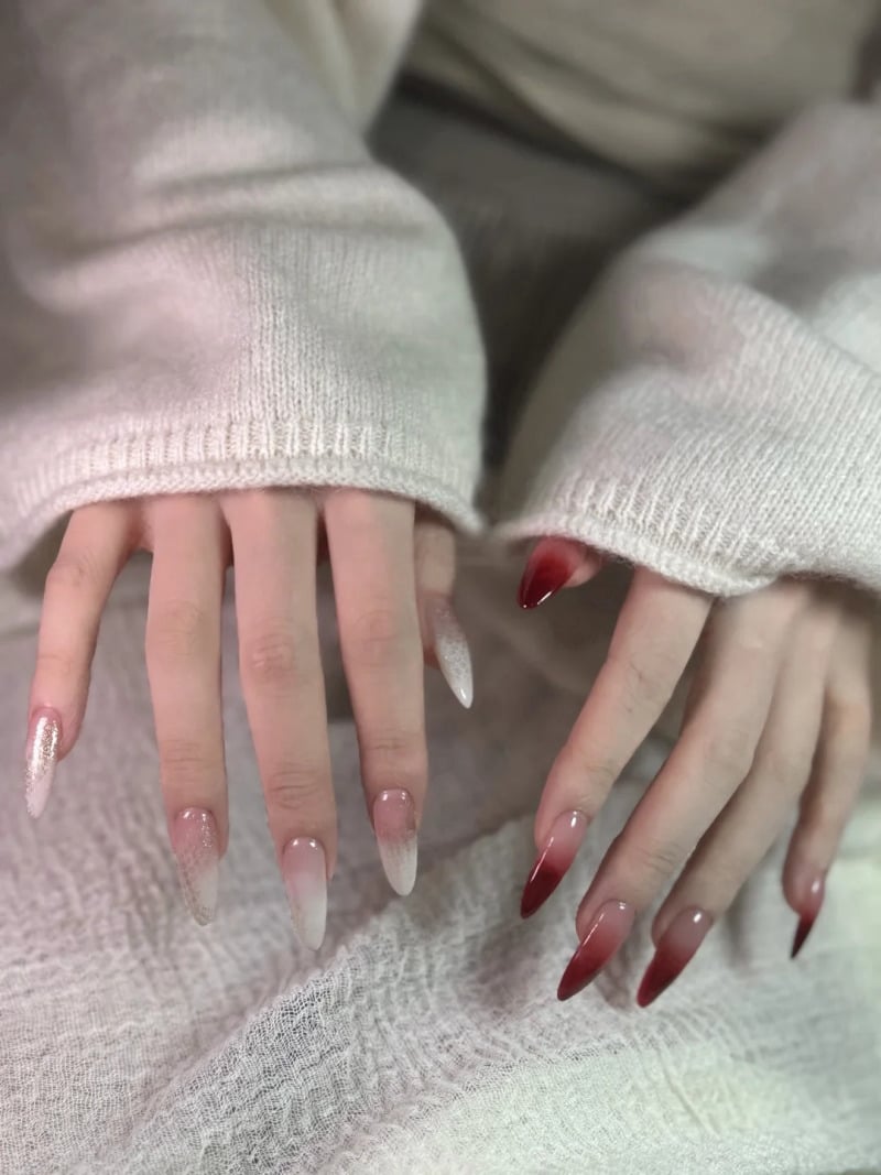 mau-nail-do-trang-cardina-10-jpg_82224e50f94a45579cba920f6f00acc5 Hai bàn tay với móng tay dài được sơn màu đỏ và trắng, áo len màu trắng.