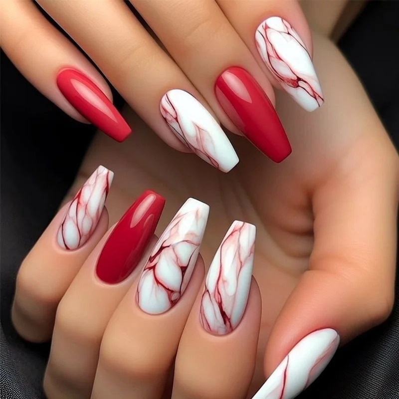mau-nail-do-trang-cardina-12-jpg_e99660bf4d3e46b9bbd15422fb8d74a4 Bộ móng tay dài được sơn màu đỏ và trắng với họa tiết vân đá tinh tế, nổi bật trên nền đen.