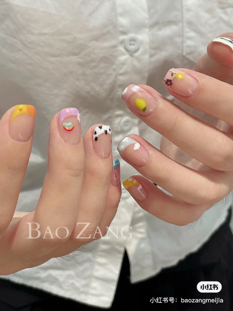 mau-nail-don-gian-cardina__102__ee8bd438ae444c4993f4eb28d1dd38bd Bàn tay với móng tay được trang trí họa tiết đa dạng và màu sắc khác nhau, trên nền áo trắng.