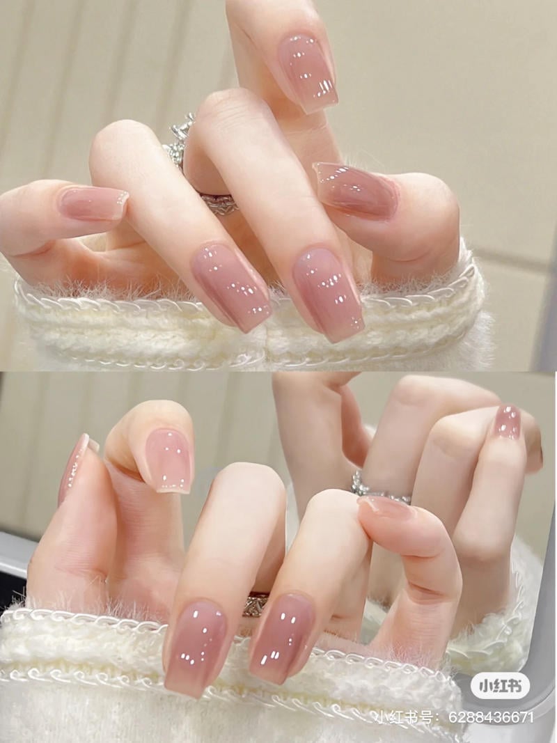 mau-nail-don-gian-cardina__76__ddf0e6bc2f4e43748dcbf30bbbdefc4e Bàn tay với móng tay được sơn màu hồng nhạt bóng, đeo nhẫn kim loại, trên nền áo len trắng.