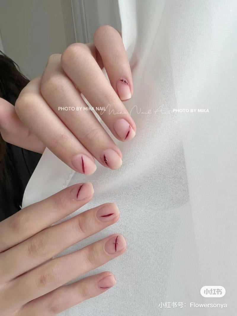 mau-nail-halloween-dep__13__e37a79c2bf6c4824aaa1d553d6d49b3c Bàn tay với móng tay được trang trí họa tiết đơn giản trên nền màu hồng nhạt.