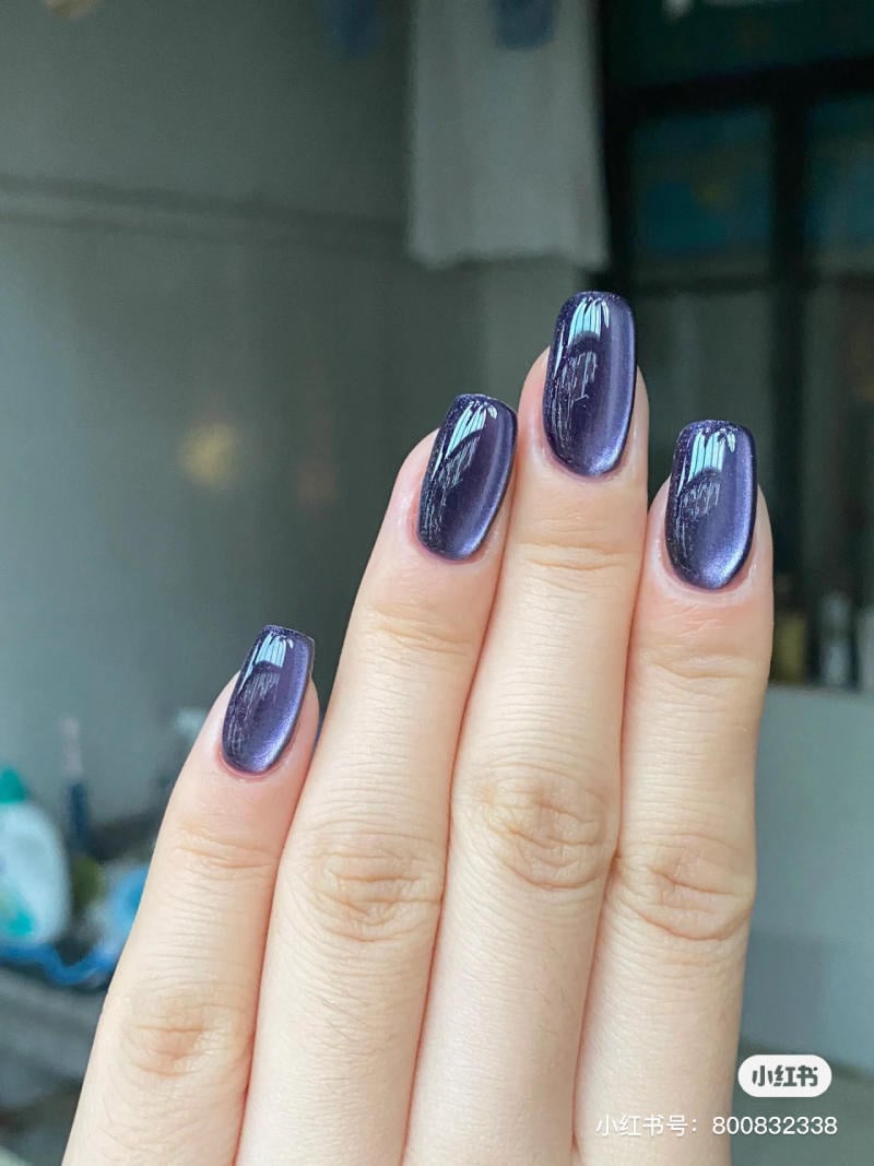 mau-nail-halloween-dep__21__fbbebb602b7843c0a1ee5c448c024f8c Bàn tay với móng tay sơn màu tím ánh kim, nền mờ, ánh sáng tự nhiên.