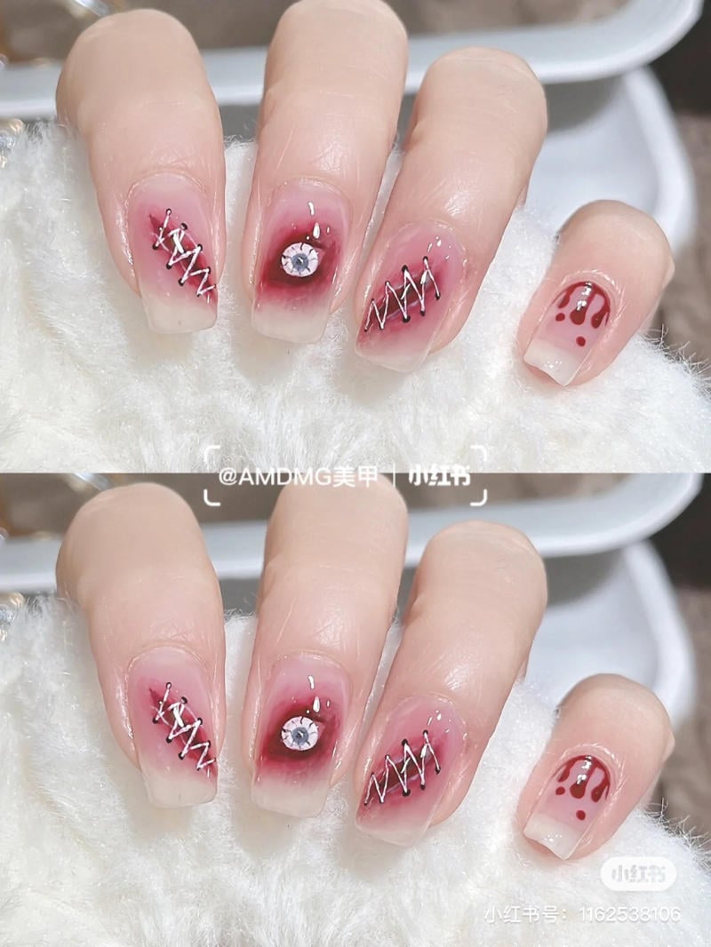 mau-nail-halloween-dep__28__3014a4c2451c4d908b5dd525588f4167 Bàn tay với móng tay được trang trí bằng hoa văn độc đáo, bao gồm đá đính và họa tiết chỉ bạc.