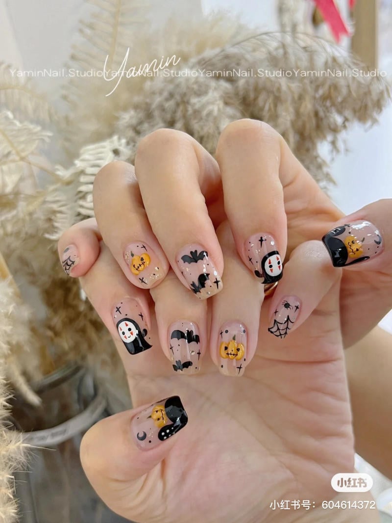 mau-nail-halloween-dep__37__3574b72b722349a7904eb6a80f6016ca Bàn tay với móng tay được trang trí họa tiết Halloween như bí ngô, dơi và mạng nhện.