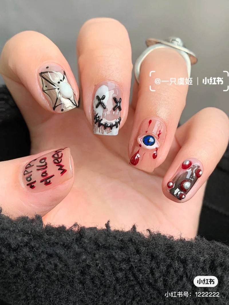 mau-nail-halloween-dep__3__b61150a54e34421182d883d11e6ebb3a Bộ móng tay trang trí với chủ đề Halloween, có họa tiết nhện, sọ người và chữ "Happy Halloween".