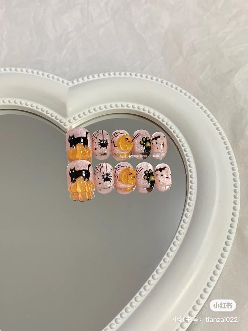 mau-nail-halloween-dep__40__5c43c85118a94b09bc4956dd198e0df3 Mẫu móng tay với hình mèo đen và bí ngô trên nền gương hình trái tim.