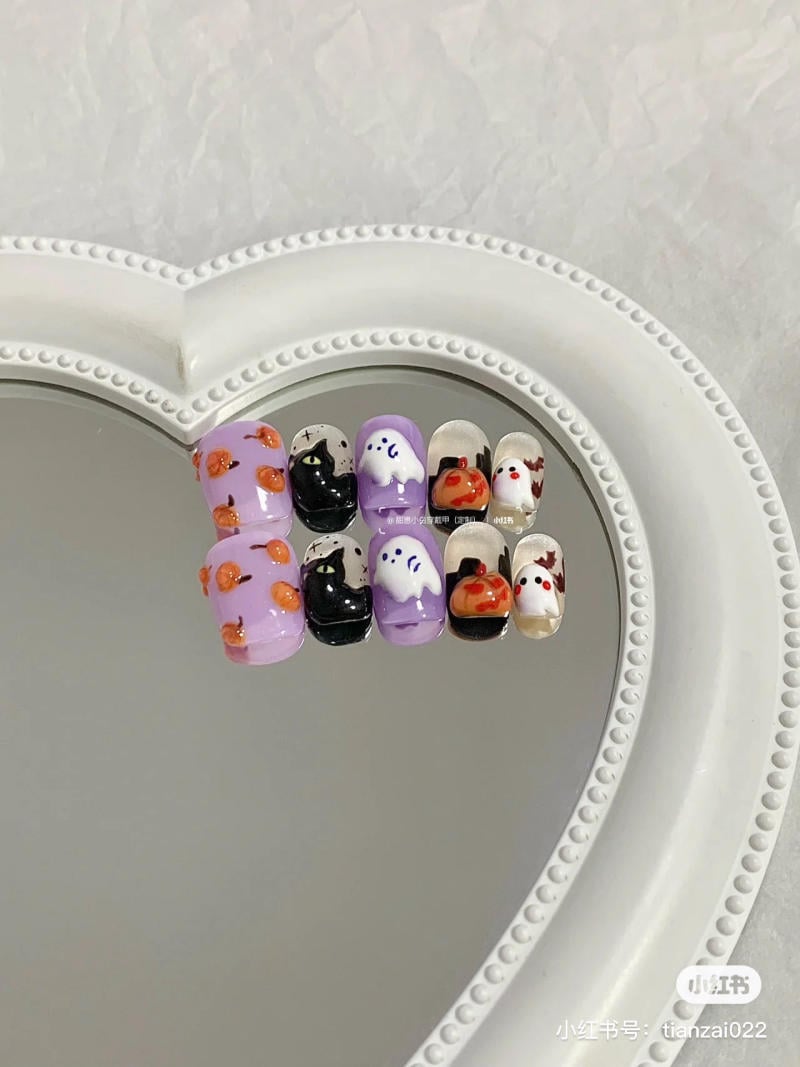 mau-nail-halloween-dep__43__a8843c5b133d4512a5bb804a8299bbc7 Bộ móng giả trang trí hình ma, mèo, bí ngô và các biểu tượng Halloween, đặt trên gương hình trái tim.