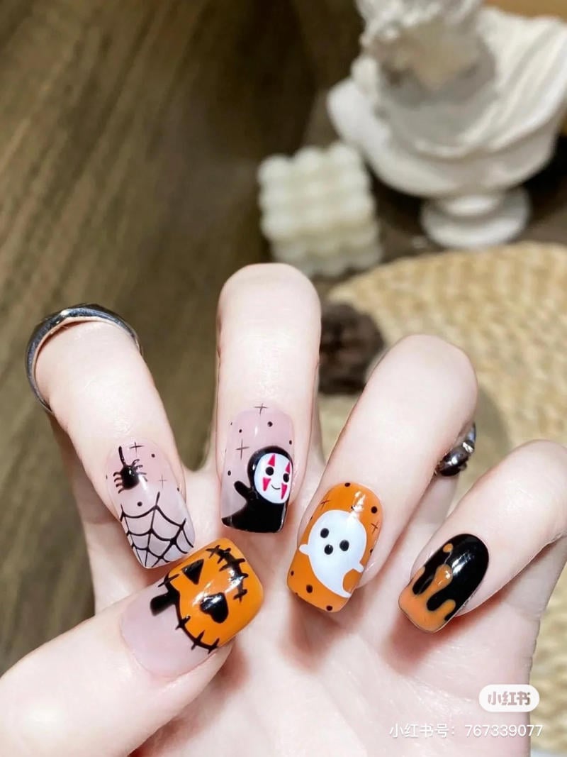 mau-nail-halloween-dep__72__83ccebb2a79d4681ae96d65f91b15408 Bộ móng tay trang trí họa tiết Halloween với bí ngô, mạng nhện và ma trên nền màu cam và đen.