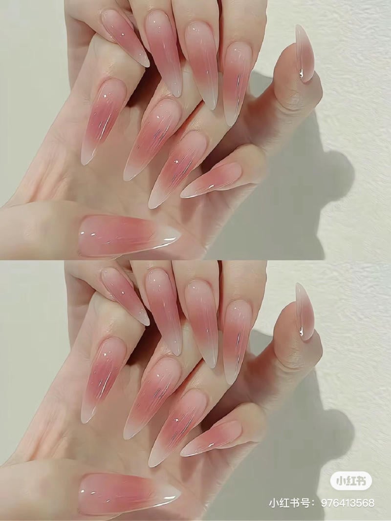 mau-nail-mong-nhon-tron__4__b561a330068944b0bb169c17921b0de3 Bàn tay với móng tay dài, nhọn, sơn màu hồng nhạt chuyển dần sang trong suốt, được chụp trên nền trắng.