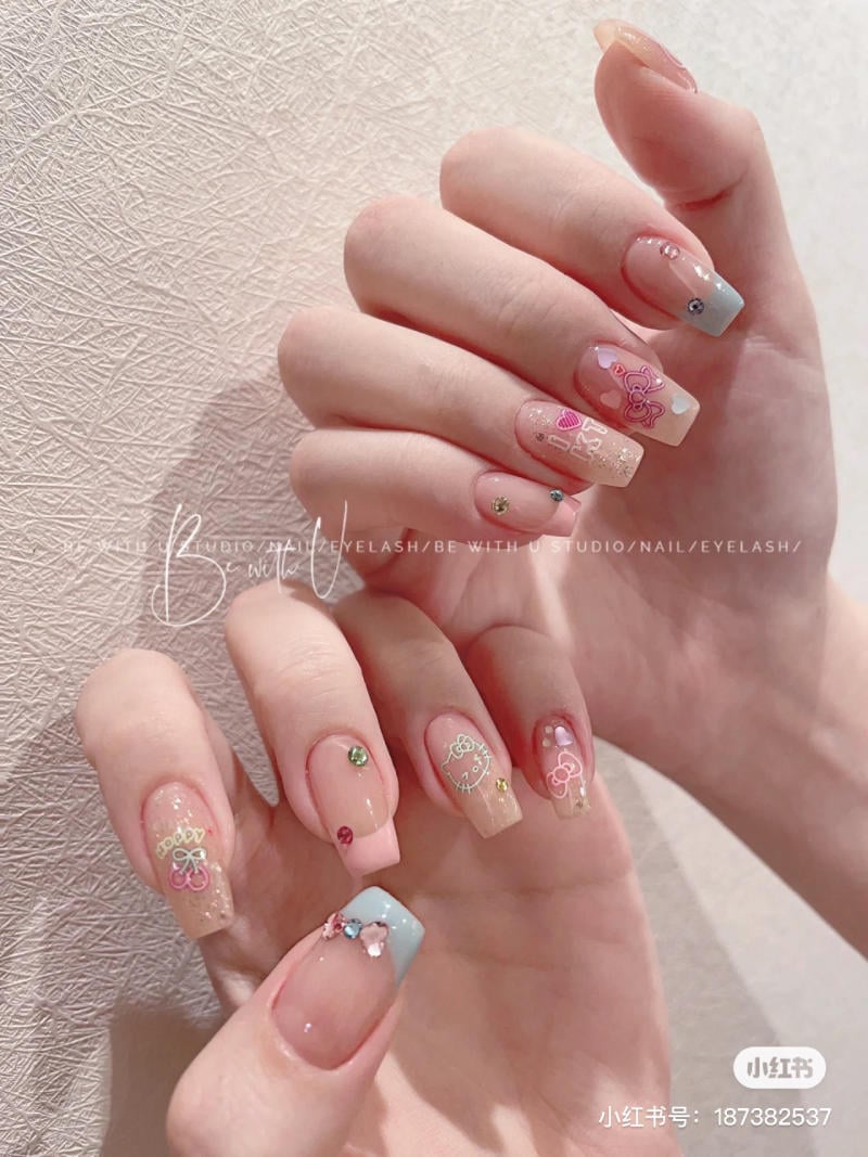 Bàn tay với móng tay được trang trí bằng họa tiết và đính đá, nền màu pastel và kim tuyến.