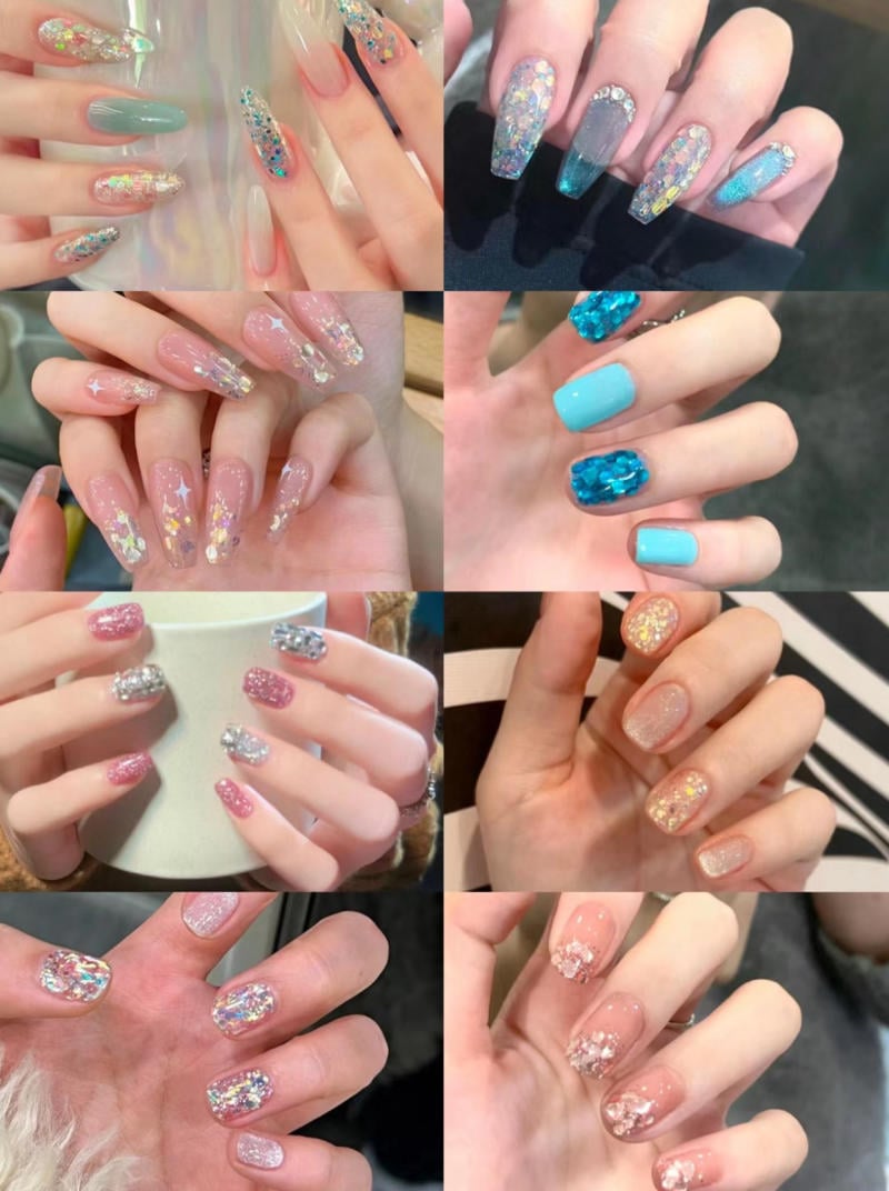 mau-nail-nhu-dep__23__4c256b94ea2c4aa9be356284e2f30325 Bộ sưu tập móng tay với nhiều thiết kế và màu sắc khác nhau, từ xanh dương đến hồng, có đính đá và phủ nhũ lấp lánh.