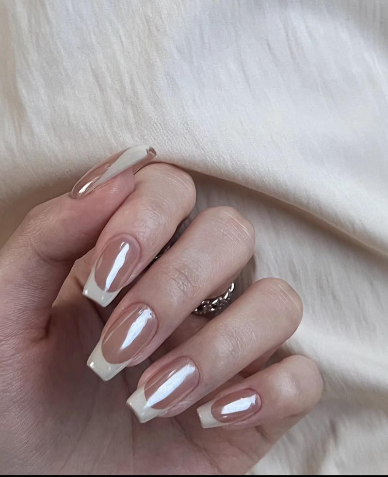 mau-nail-nhu-dep__33__de82e0575b00489383d06813e91a9bf3 Bàn tay với móng tay được sơn kiểu French, nền vải trắng nhăn nhẹ.