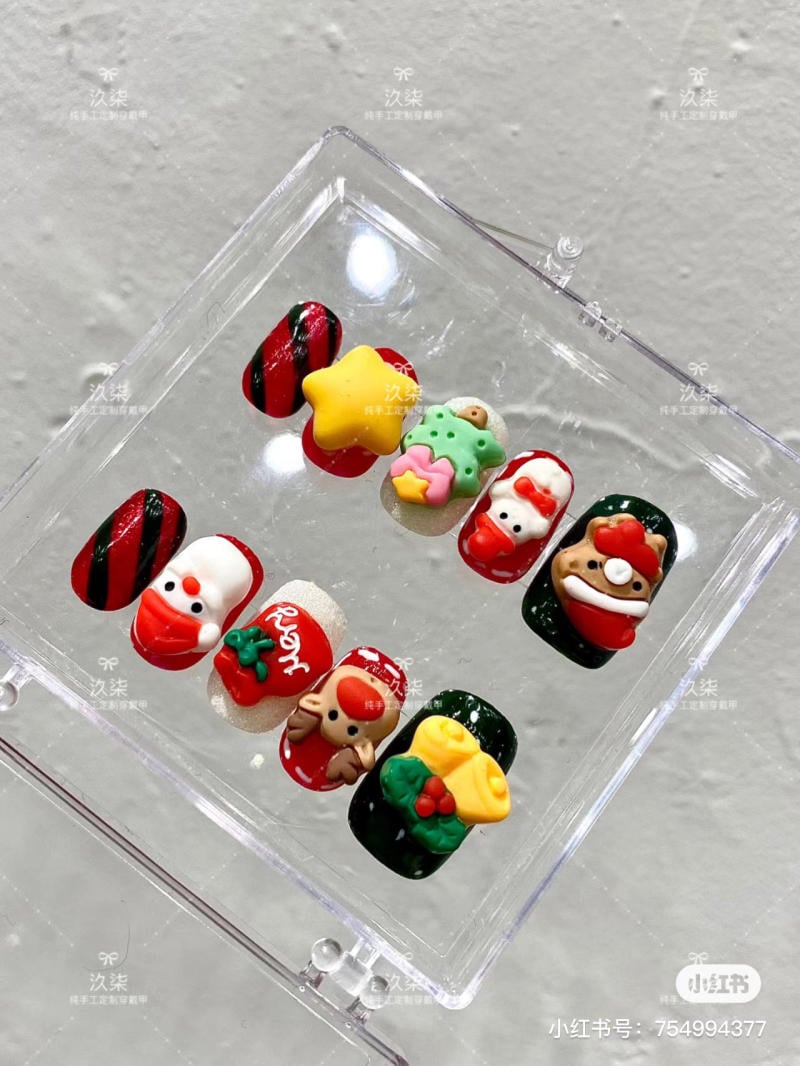 mau-nail-noel-dep__24__664b14bf45ac4410b4f214ff6f252ecf Bộ móng tay giả với các họa tiết Giáng Sinh như cây thông, ngôi sao, và nhân vật trang trí đầy màu sắc.