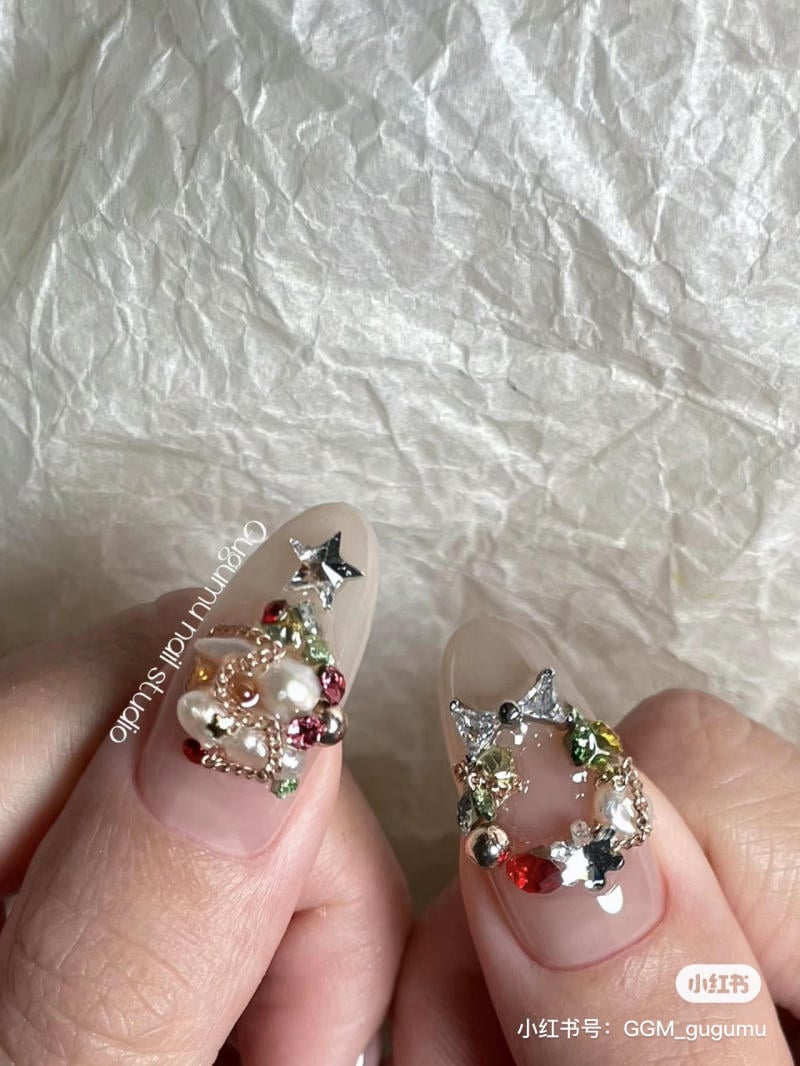 mau-nail-noel-dep__33__fcf9013ff4ba41d081395bbe0ca7d6d9 Hai móng tay được trang trí nghệ thuật với ngọc trai và đá quý nhiều màu sắc trên nền trong suốt.