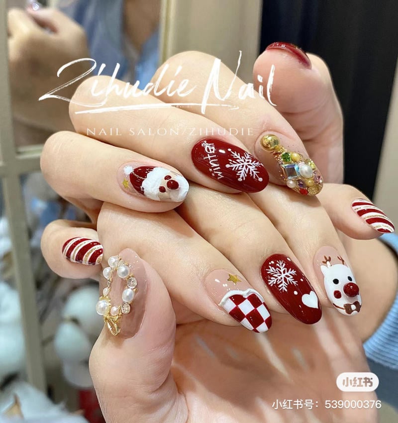 mau-nail-noel-dep__71__30daec1006604b18935490e3a1cc40d4 Mẫu móng tay trang trí hình ông già Noel, bông tuyết, và họa tiết Noel với màu đỏ và trắng nổi bật.