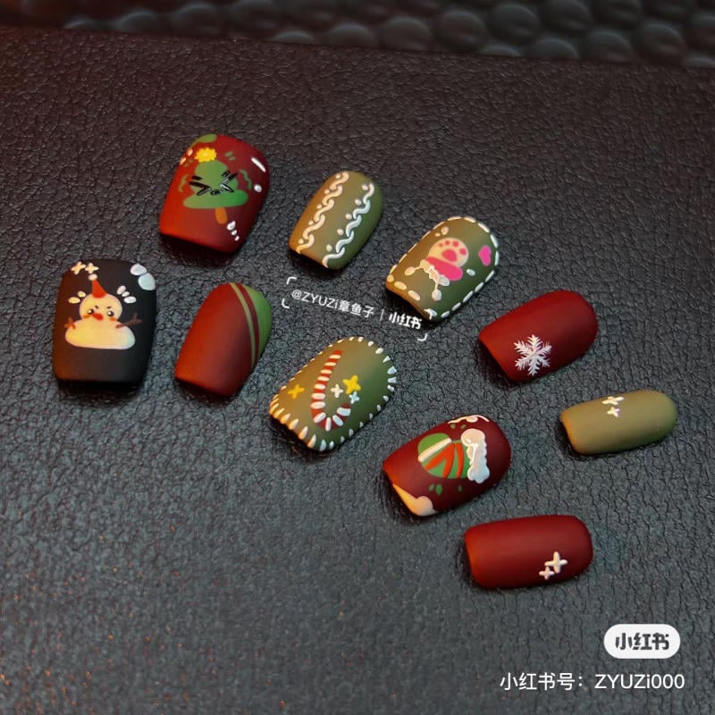 mau-nail-noel-dep__77__8c8217de5ddb494bad3a3129a2b47043 Bộ móng tay giả với nhiều họa tiết Giáng sinh đa dạng, màu sắc xanh, đỏ, và nâu trên nền đen.