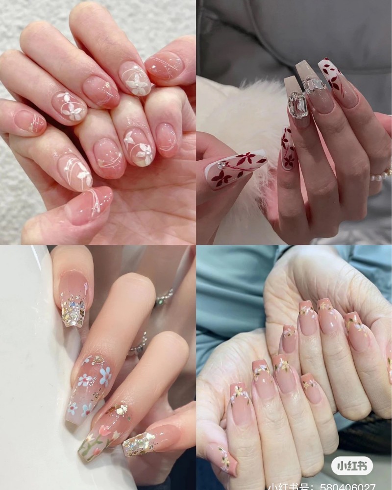 Bốn kiểu móng tay khác nhau với họa tiết hoa trang trí tinh tế và đa dạng trên nền màu hồng nhạt.