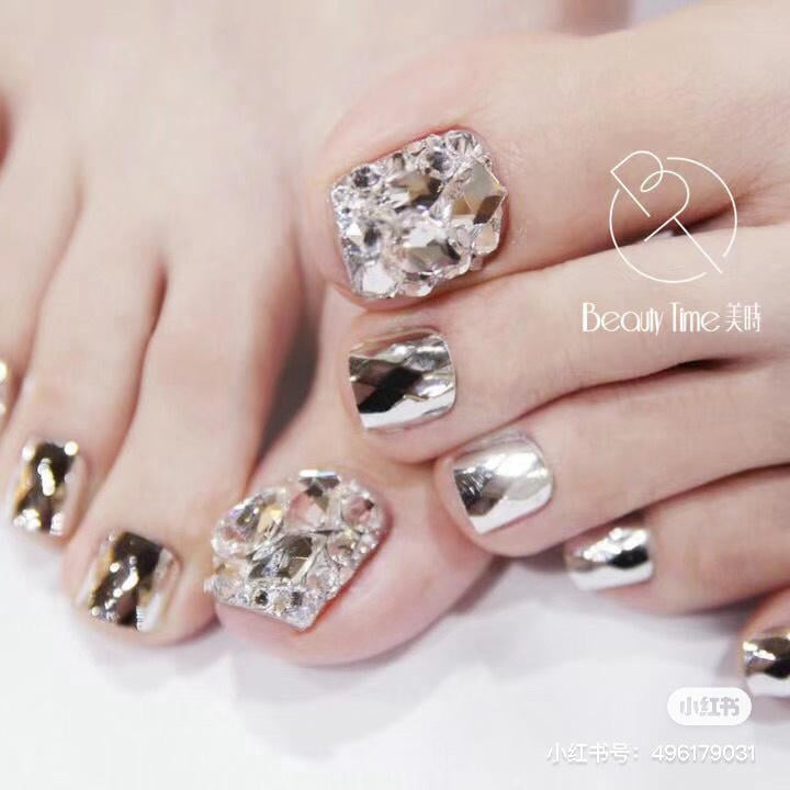 nai-chan-dinh-da__6__9b557262cd3c41f9b32ceb0c36c9cc05 Bàn chân và tay với móng được trang trí bằng đá và sơn bóng ánh kim loại.