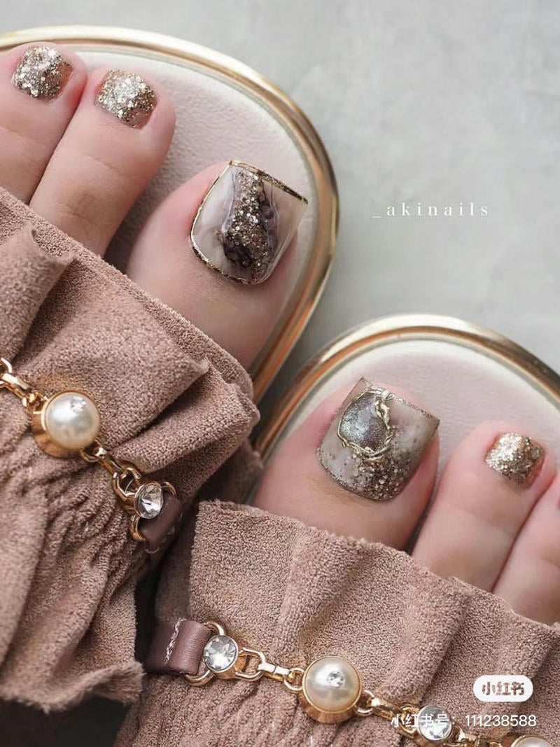nail-chan-dinh-da__55__97668c1645714cee9b7c96363c8720c3 Bàn chân với móng chân được trang trí công phu bằng họa tiết lấp lánh, mang dép có phụ kiện ngọc trai.