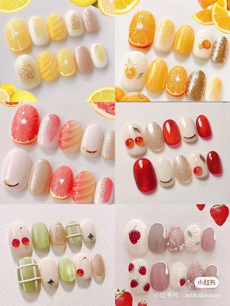 Mẫu nail nghệ thuật với họa tiết trái cây và màu sắc tươi sáng, gồm cam, chanh, dâu, anh đào và các màu nhũ.