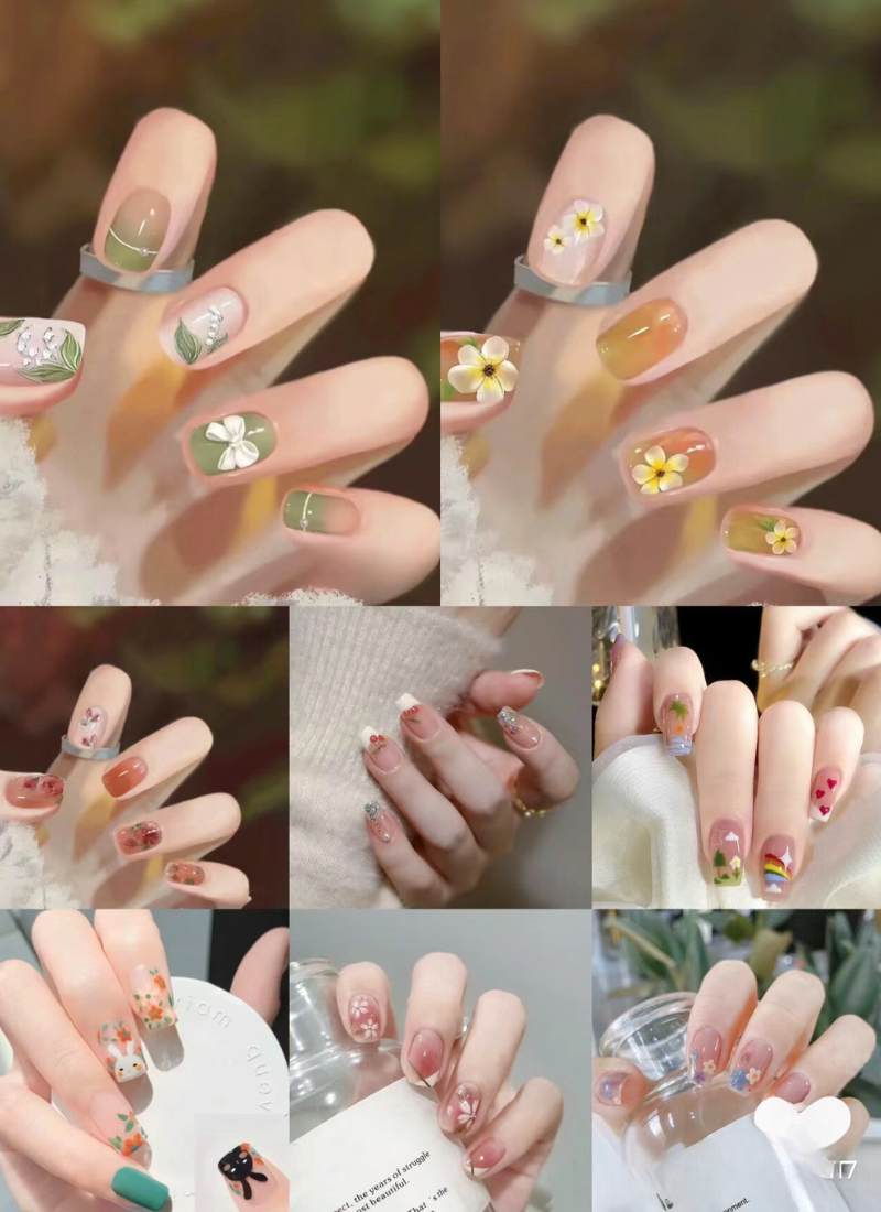 Tay với móng tay được trang trí nghệ thuật với nhiều màu sắc và họa tiết hoa, lá, và hình vẽ sáng tạo.