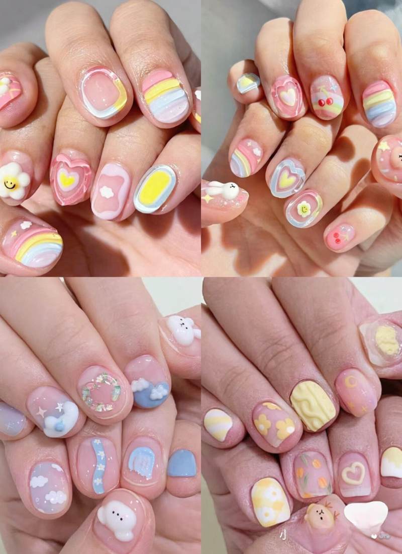 Bộ móng tay trang trí với các họa tiết màu sắc đa dạng như trái tim, cầu vồng, và hoa, mang phong cách dễ thương.